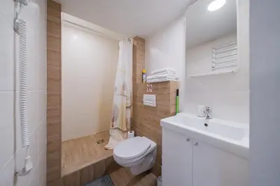 a white bathroom with a toilet and a sink at Kauno Mini Loft by Lollo Stay in Vilnius