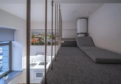 a room with a long row of beds and a window at Kauno Mini Loft by Lollo Stay in Vilnius