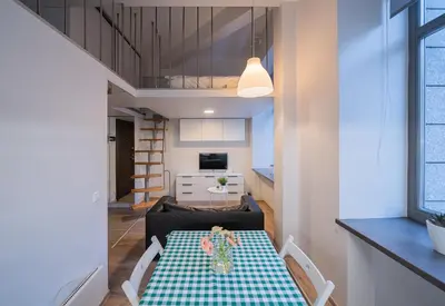 a living room with a table and a kitchen at Kauno Mini Loft by Lollo Stay in Vilnius