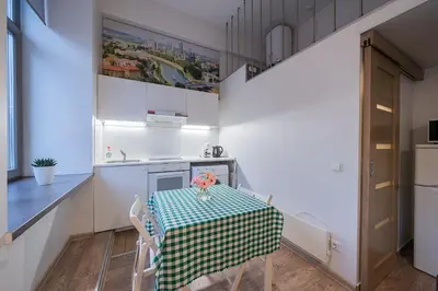 a small kitchen with a table with a green and white table cloth at Kauno Mini Loft by Lollo Stay in Vilnius