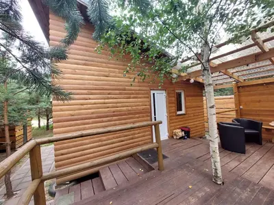 a wooden cabin with a bench on a deck at Pasakų pirtelė in Vilnius