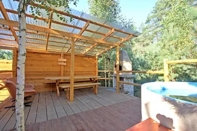 a wooden deck with a bench and a pergola at Pasakų pirtelė in Vilnius