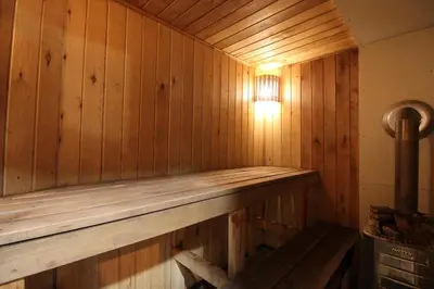 a wooden sauna with a light on the wall at Pasakų pirtelė in Vilnius