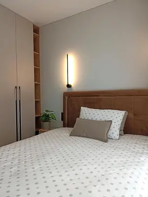 a bedroom with a large bed with a wooden headboard at Apartments with an impressive terrace on the roof of the house in Vilnius