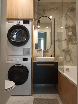 a bathroom with a washing machine and a sink at Apartments with an impressive terrace on the roof of the house in Vilnius