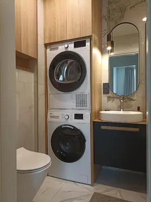 a bathroom with a washing machine and a sink at Apartments with an impressive terrace on the roof of the house in Vilnius