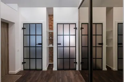 a room with glass doors and a brick wall at Bravo Apartments in Kaunas