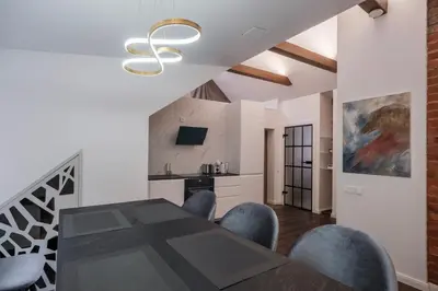 a dining room with a table and blue chairs at Bravo Apartments in Kaunas