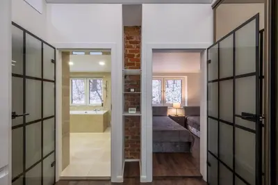 a bathroom with a door leading to a bedroom with a tub at Bravo Apartments in Kaunas