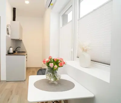 a vase of flowers sitting on a table in a kitchen at Central Station Apartment No5 in Kaunas