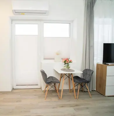 a dining room with a table and chairs and a tv at Central Station Apartment No5 in Kaunas