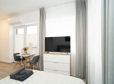 a bedroom with a bed and a tv and a table at Central Station Apartment No5 in Kaunas