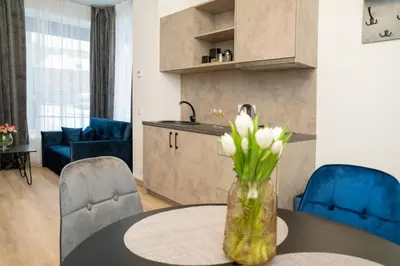 a kitchen and living room with a table with flowers on it at Central Station Apartment No4 in Kaunas