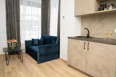 a living room with a blue couch and a table at Central Station Apartment No4 in Kaunas