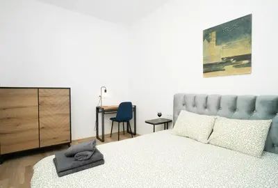 a bedroom with a bed and a desk with a chair at Central Station Apartment No4 in Kaunas