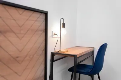 a desk with a blue chair next to a door at Central Station Apartment No4 in Kaunas