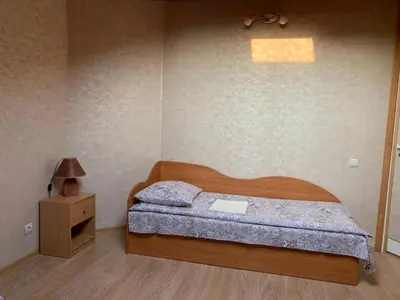 a bedroom with a wooden bed and a night stand at Saldus sapnas in Rokiškis