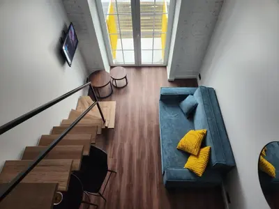 an overhead view of a staircase with yellow pillows at Radio city loft-468 in Kaunas