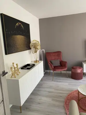 a living room with a red chair and a table at Marijos apartamentai in Birštonas