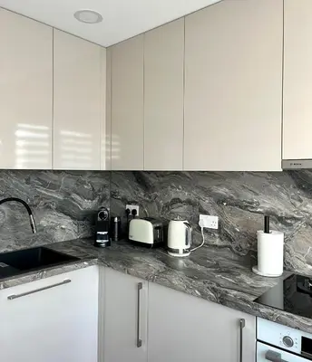 a kitchen with white cabinets and white appliances at Marijos apartamentai in Birštonas