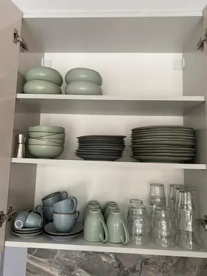 a shelf filled with dishes and bowls and plates at Marijos apartamentai in Birštonas