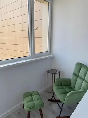 a room with two green chairs and a window at Marijos apartamentai in Birštonas