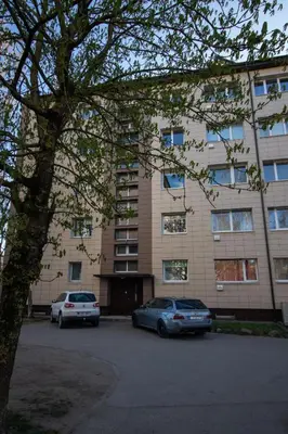 two cars parked in a parking lot in front of a building at Jaukus butas pačioje miesto širdyje in Šiauliai