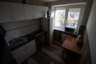 a small kitchen with a sink and a refrigerator at Jaukus butas pačioje miesto širdyje in Šiauliai