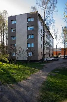 a large building with cars parked in front of it at Jaukus butas pačioje miesto širdyje in Šiauliai