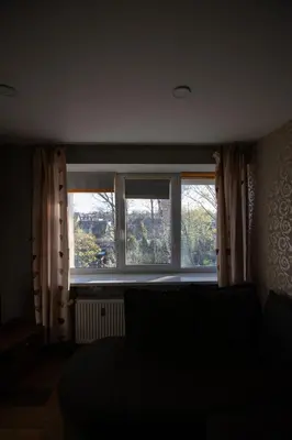 a living room with a large window and a couch at Jaukus butas pačioje miesto širdyje in Šiauliai