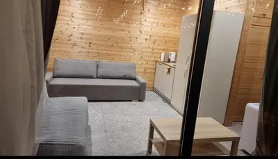 a living room with a couch and a refrigerator at Poilsiaviete Vakaris in Gudeliai