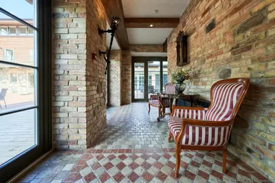 a room with two chairs and a brick wall at Užutrakio rezidencija in Trakai
