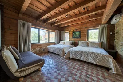 a bedroom with two beds and a chair and windows at Užutrakio rezidencija in Trakai