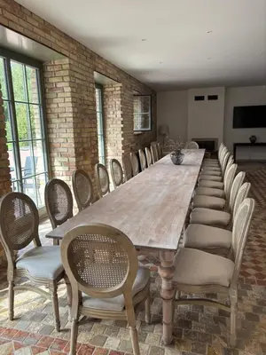 a large wooden table with chairs and a long table at Užutrakio rezidencija in Trakai