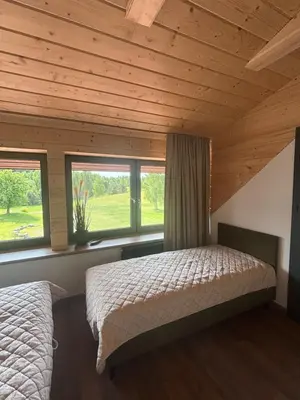 a bedroom with two beds in a room with windows at Užutrakio rezidencija in Trakai