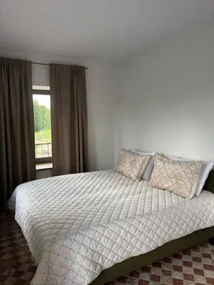 a bedroom with a large bed with a window at Užutrakio rezidencija in Trakai