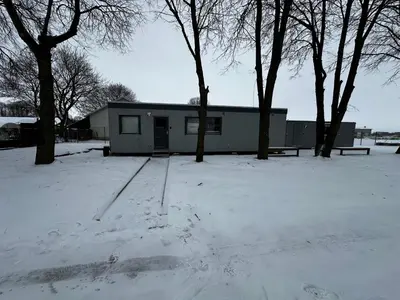a house in a snow covered yard with trees at Dvaro namai in Norgėlai