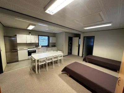 a large room with a table and a kitchen at Dvaro namai in Norgėlai