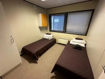 a small room with two beds and two windows at Dvaro namai in Norgėlai
