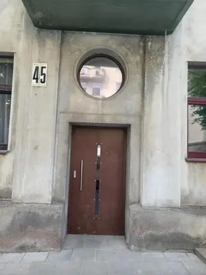 a building with a brown door with a window at Kauno apartamentai big room king size bed in Kaunas
