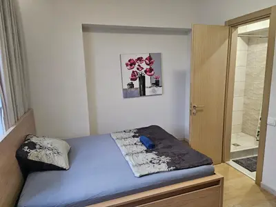 a small bedroom with a bed and a door at Kauno apartamentai big room king size bed in Kaunas