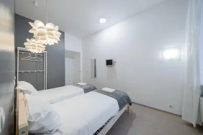 a bedroom with two beds and a chandelier at Halės Self Check-in Guest House - Lollo Stay in Vilnius