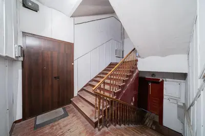 a staircase in an old building with a wooden door at Halės Self Check-in Guest House - Lollo Stay in Vilnius