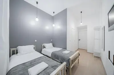 two beds in a room with white walls at Halės Self Check-in Guest House - Lollo Stay in Vilnius