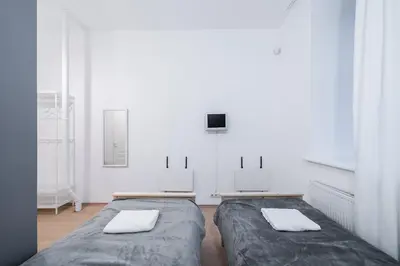two beds in a room with white walls at Halės Self Check-in Guest House - Lollo Stay in Vilnius