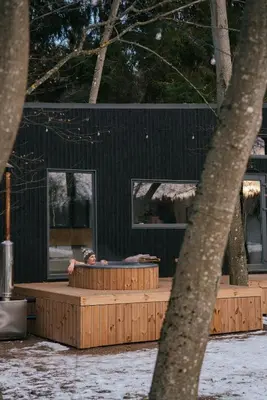 a man sitting at a table in front of a building at Living art piece at the lake. in Užutrakis