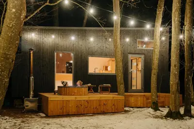 a person sitting at a table in a building at night at Living art piece at the lake. in Užutrakis