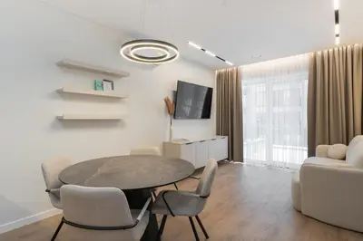 a living room with a table and chairs at Hygge Sand Apartment in Vilnius