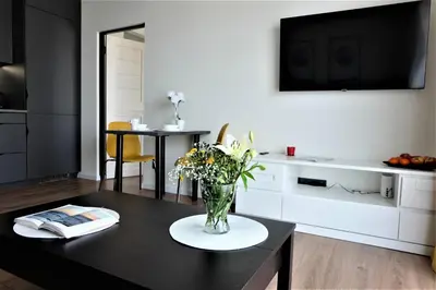 a living room with a vase of flowers on a table at Nauji apartamentai su kiemeliu in Kaunas