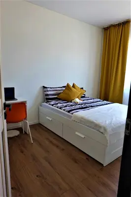 a bed with yellow pillows on it in a bedroom at Nauji apartamentai su kiemeliu in Kaunas